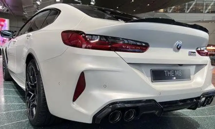 BMW M8 Coupe putih diparkir di depan gedung modern