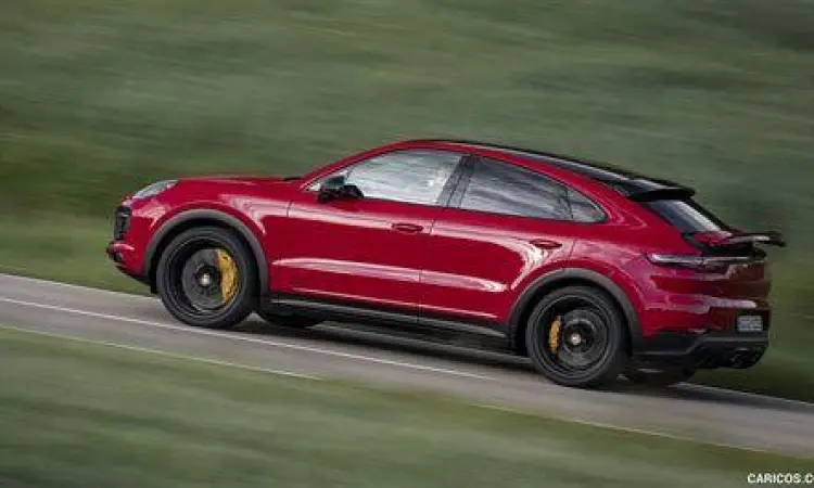 Mobil Porsche Cayenne merah sedang melaju di pegunungan