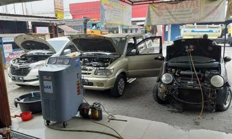 Servis AC Mobil Profesional Teknisi sedang memperbaiki AC mobil