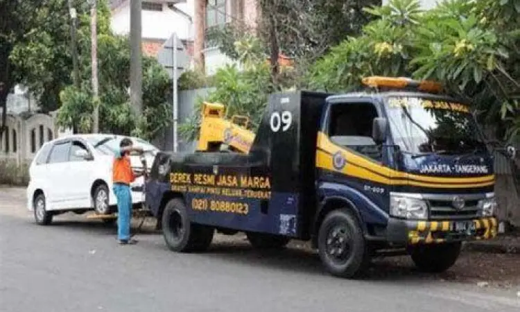 Derek Resmi Jalan Tol Petugas derek resmi jalan tol sedang mengevakuasi mobil