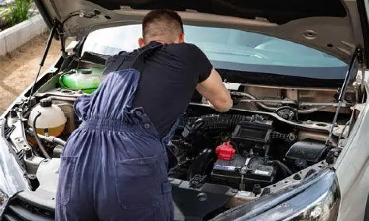 Mekanik sedang melakukan inspeksi mesin mobil bekas