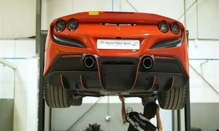 Mekanik sedang melakukan pengecekan pada mesin Ferrari di bengkel resmi