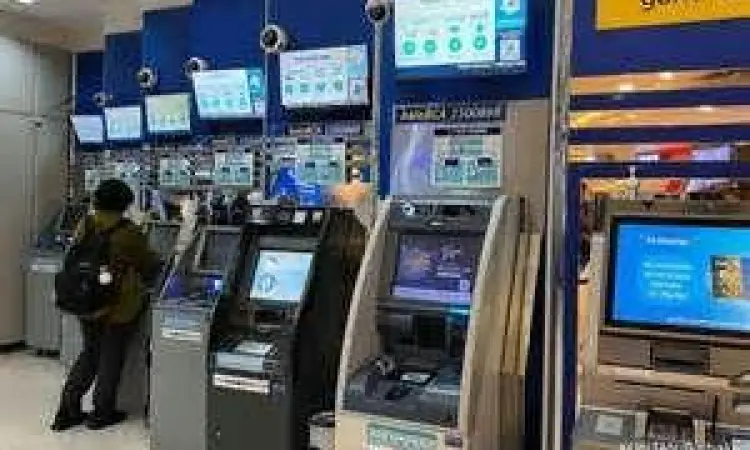 Nasabah sedang memasukkan kartu ke ATM BCA