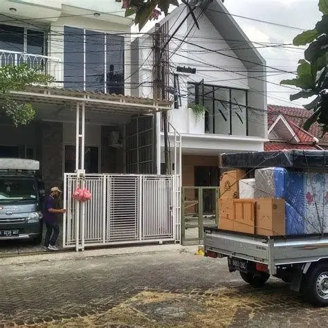 Layanan Tenaga Angkut Petugas sedang mengangkut barang pindahan ke mobil pick up